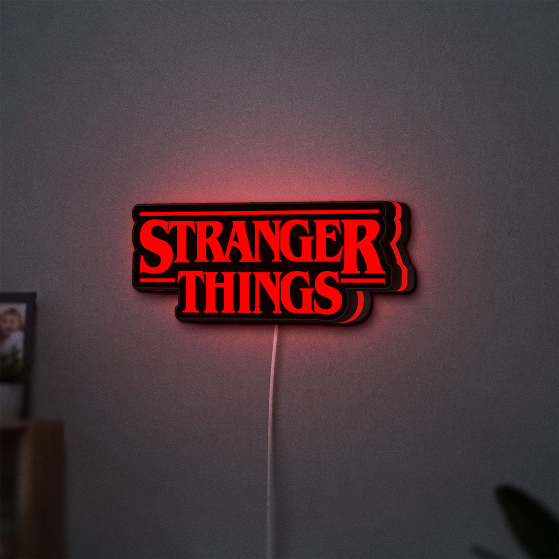 Stranger Things Logo The Upside Down LED lightbox hanging on a wall with red glow
