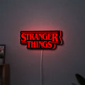 Stranger Things Logo The Upside Down LED lightbox hanging on a wall with red glow