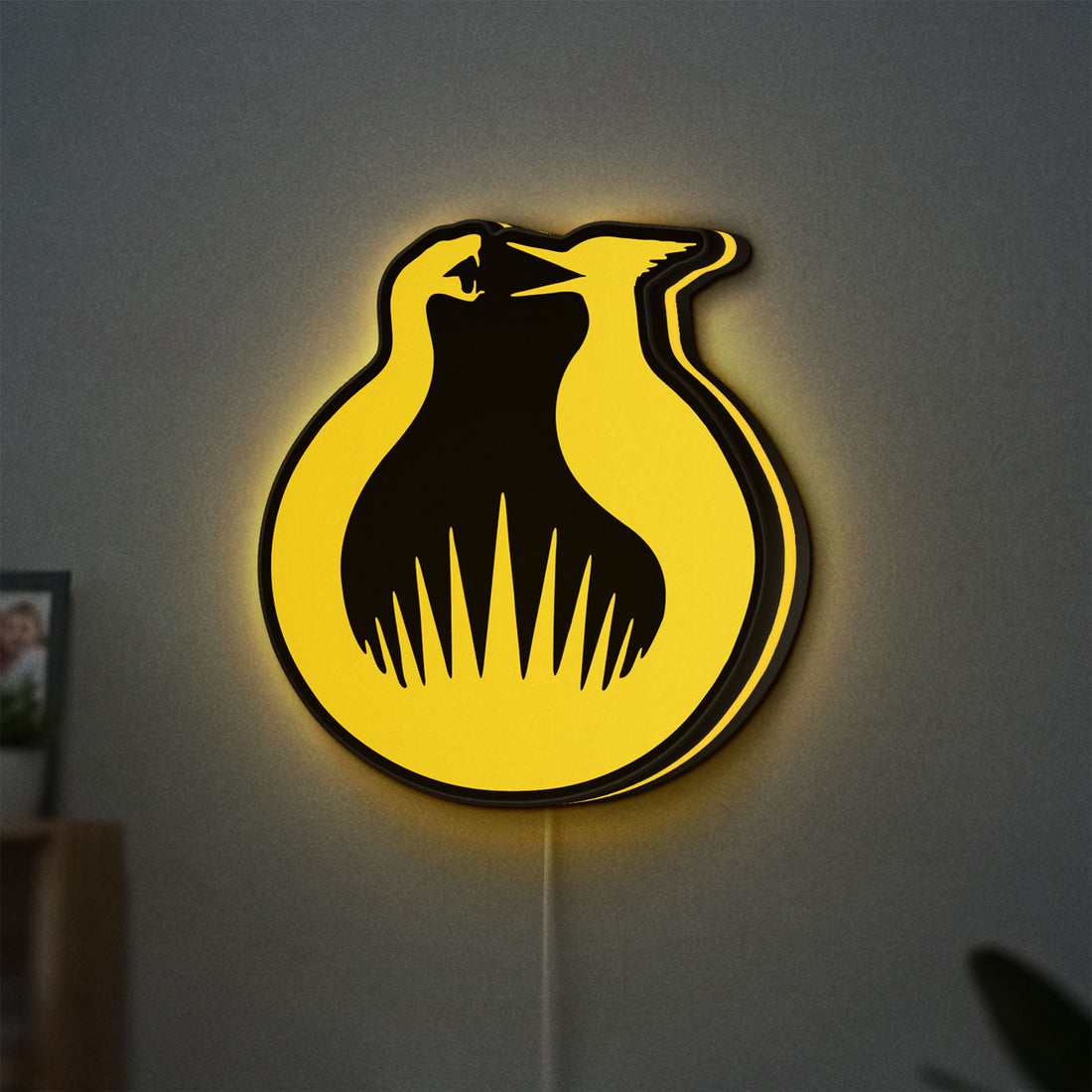 Hunger Games Sunrise on the Reaping LED lightbox hanging on a wall with yellow glow