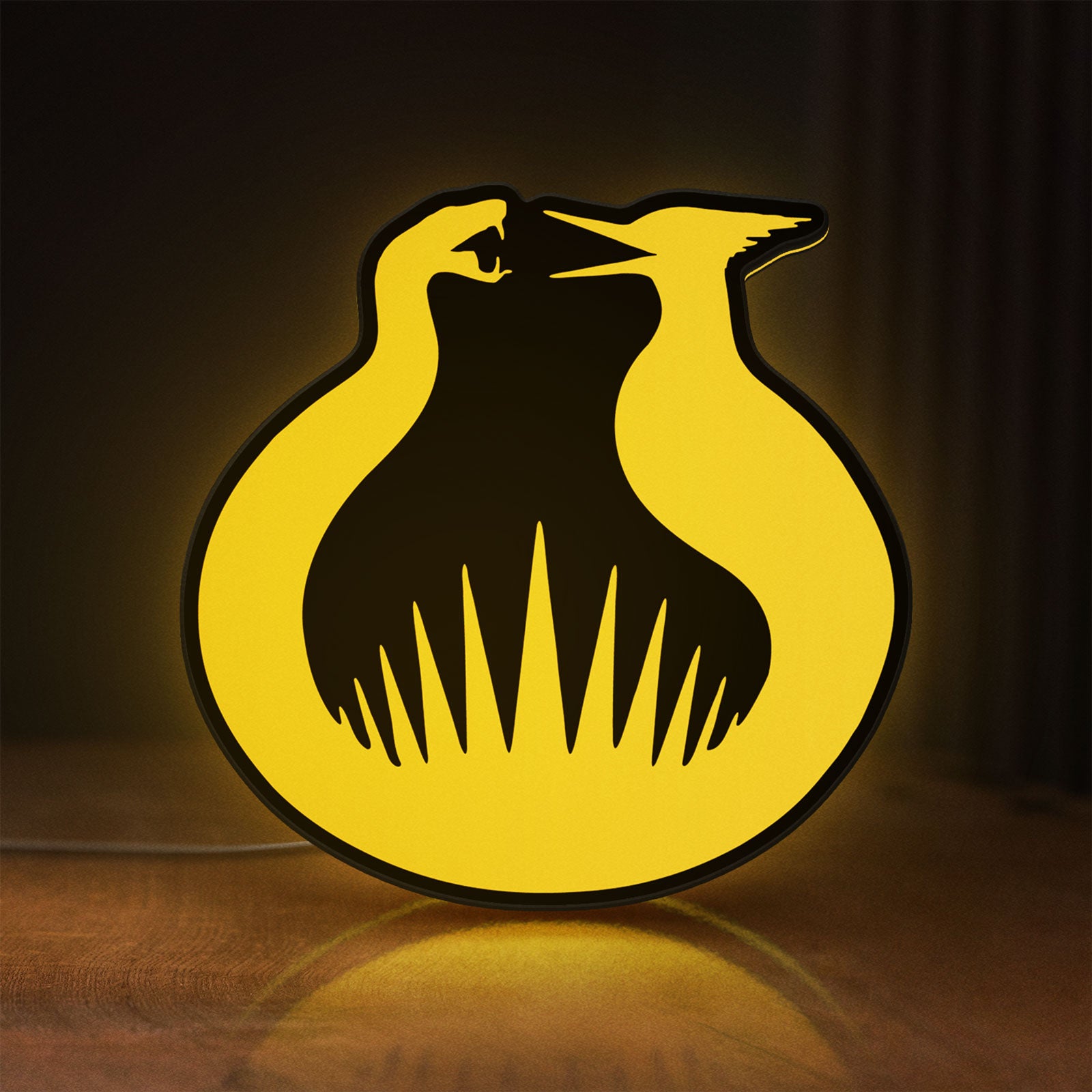 Front view of Hunger Games Sunrise on the Reaping LED lightbox sign glowing on a wooden desk
