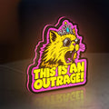 This is an Outrage Meme Funny Quote LED lightbox standing on a desk from an angled side view with pink glow