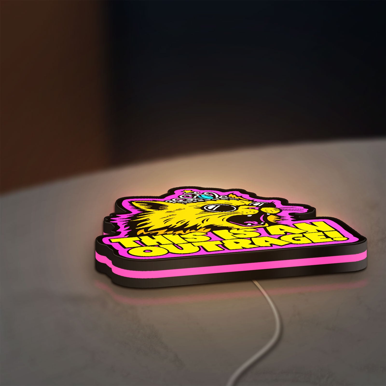 This is an Outrage Meme Funny Quote LED lightbox lying flat on a desk with pink glow