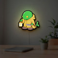 Final Fantasy Tonberry RPG Monster LED lightbox hanging on a room wall with soft green light