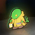 Final Fantasy Tonberry RPG Monster LED lightbox standing on a desk from an angled side view with green glow