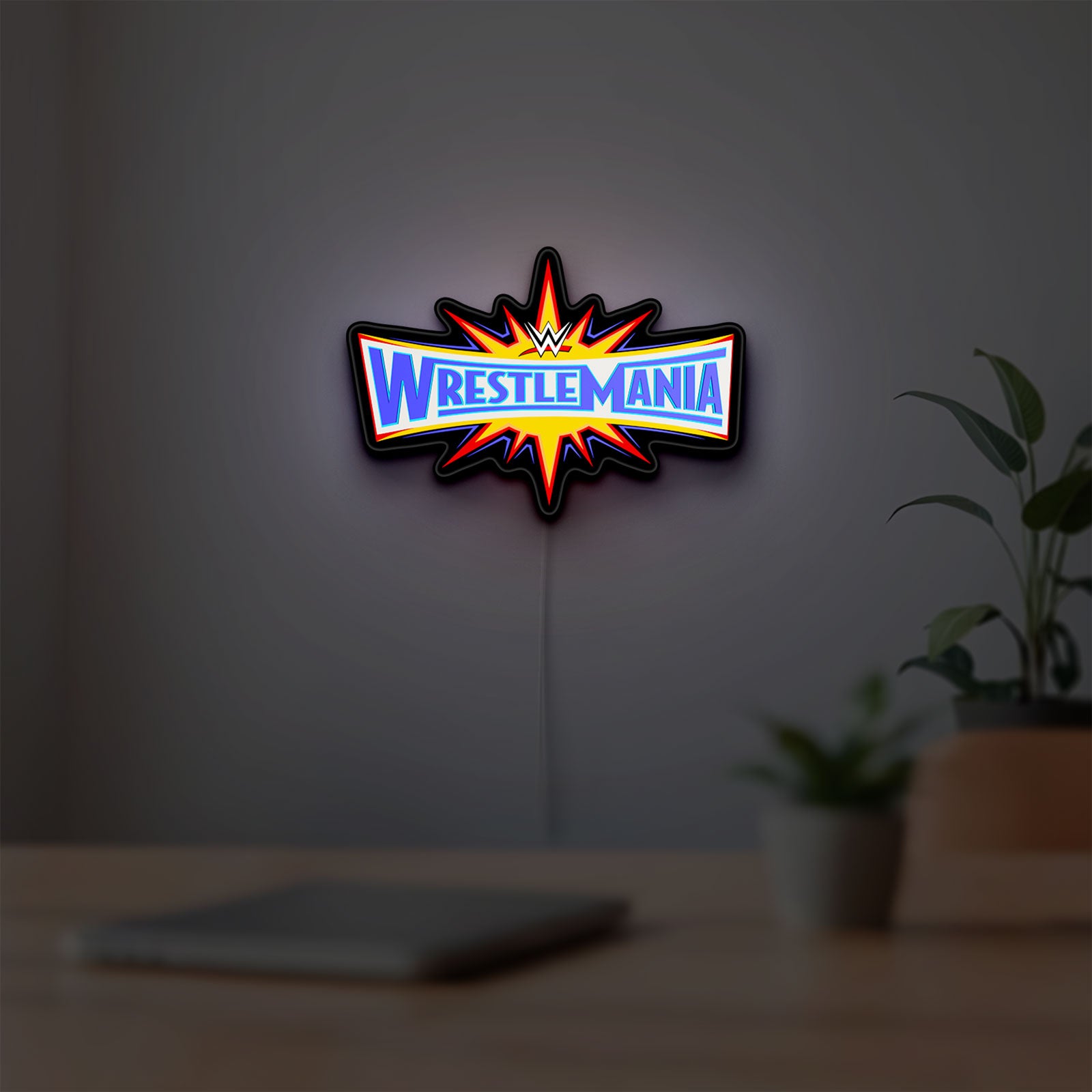WWE WrestleMania Pro Wrestling LED lightbox hanging on a room wall with soft yellow light