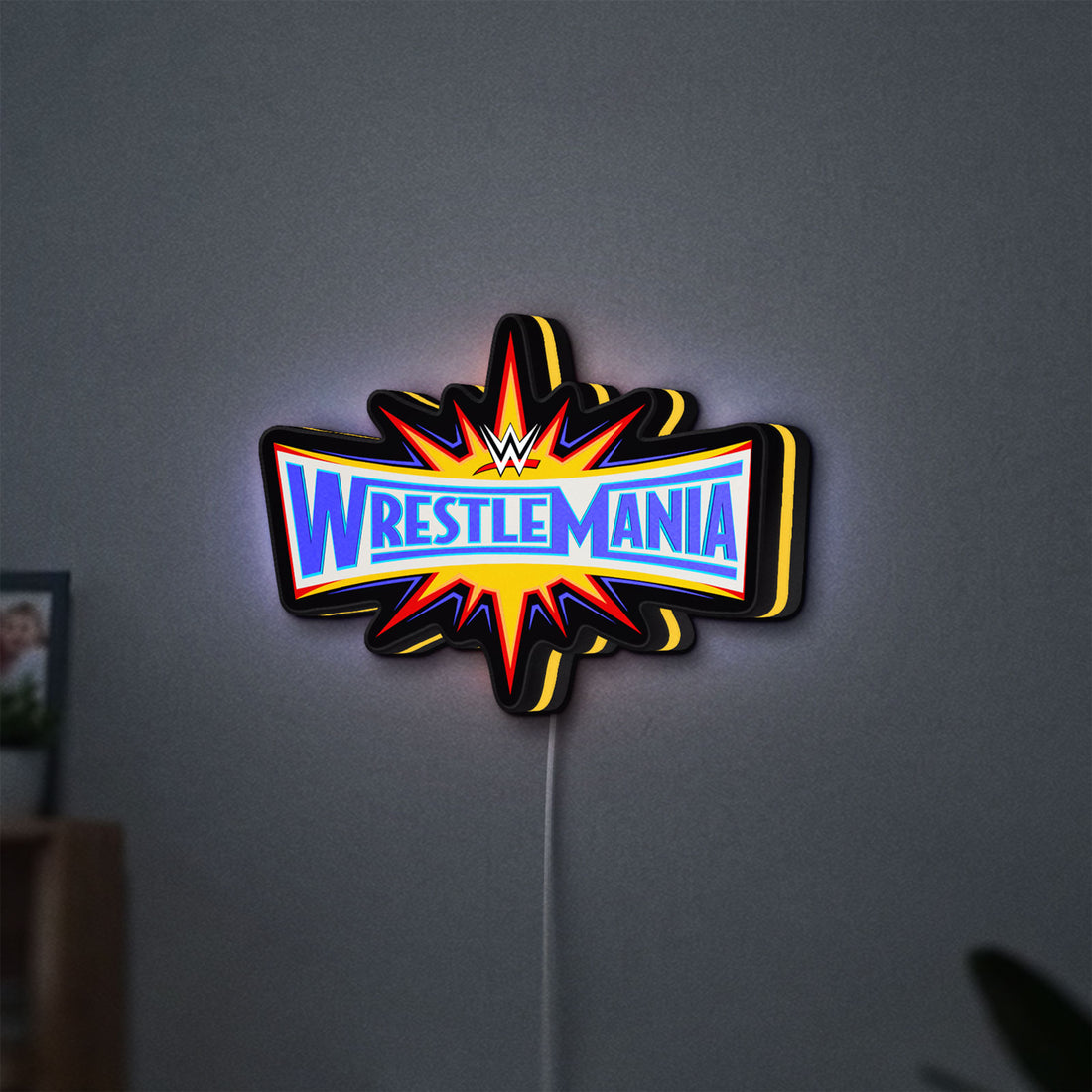 WWE WrestleMania Pro Wrestling LED lightbox hanging on a wall with yellow glow