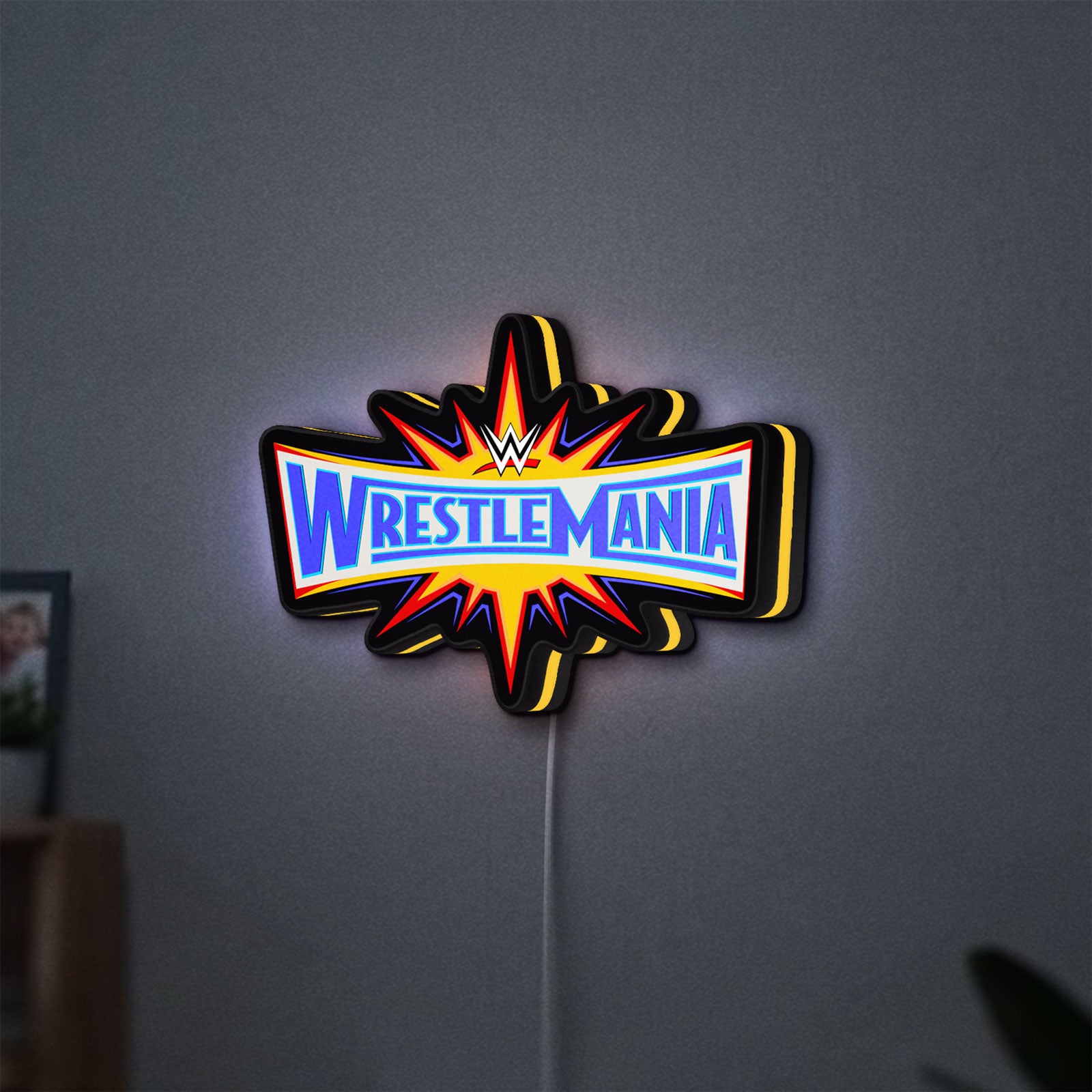 WWE WrestleMania Pro Wrestling LED lightbox hanging on a wall with yellow glow