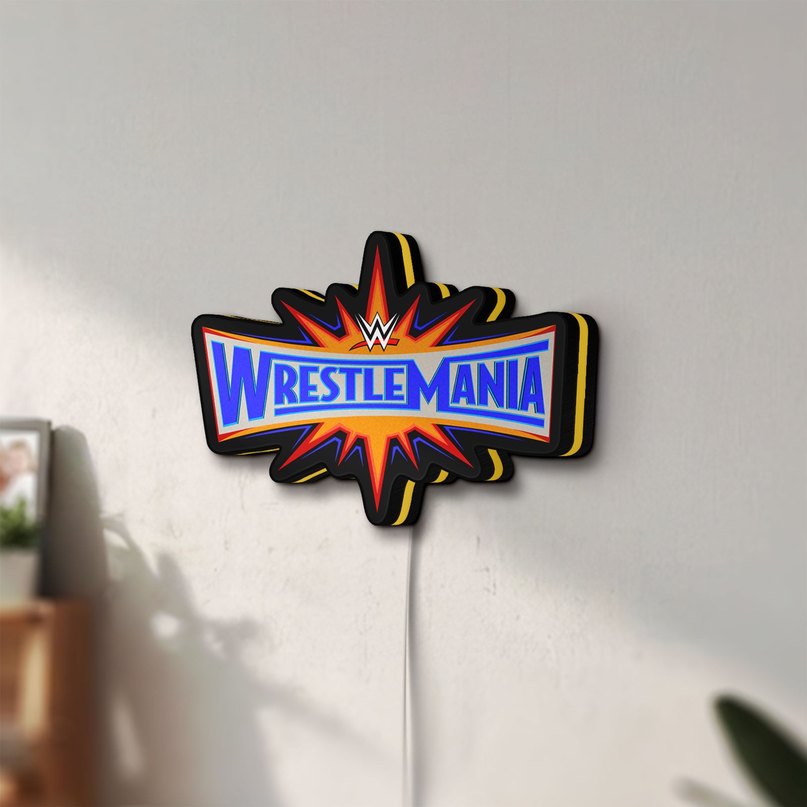 Unlit WWE WrestleMania Pro Wrestling LED lightbox mounted on a wall in daylight