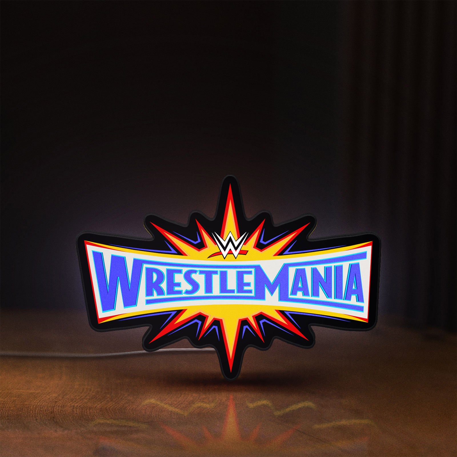 Front view of WWE WrestleMania Pro Wrestling LED lightbox sign glowing on a wooden desk