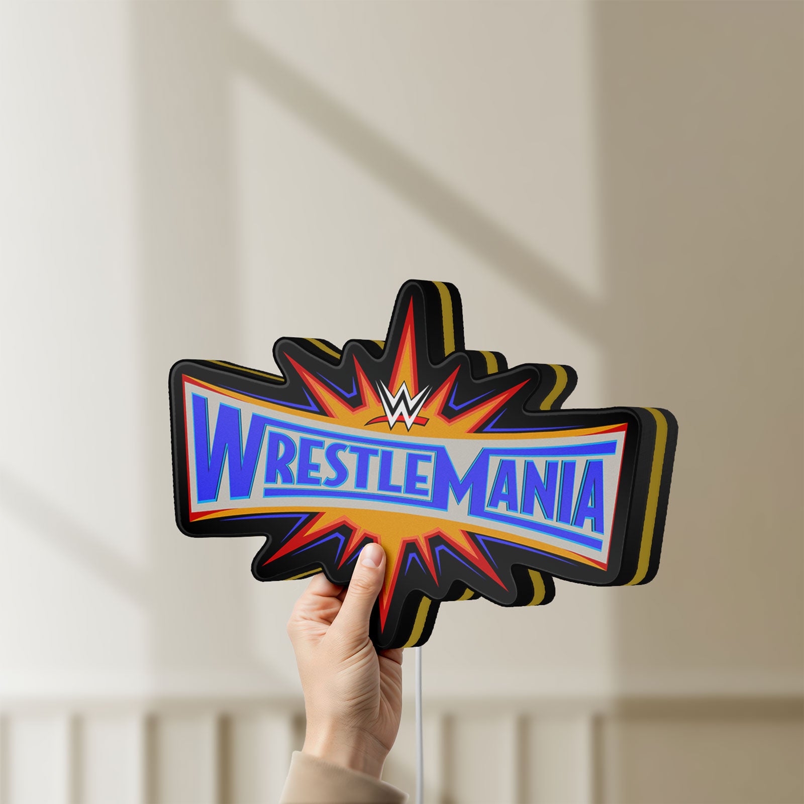 Unlit WWE WrestleMania Pro Wrestling LED lightbox held by hand to show size and details