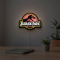 Jurassic Park LED lightbox hanging on a room wall with soft yellow light