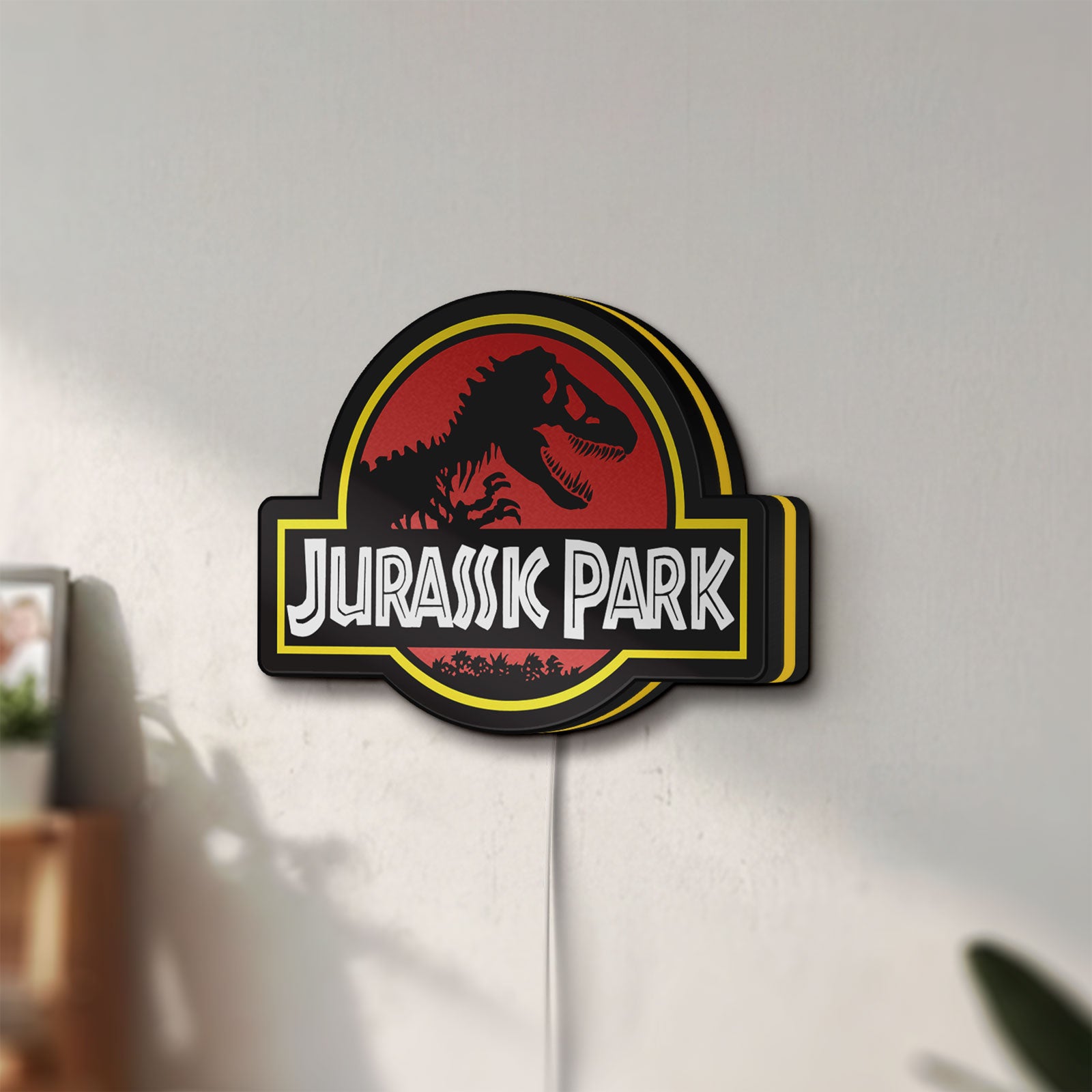 Unlit Jurassic Park LED lightbox mounted on a wall in daylight