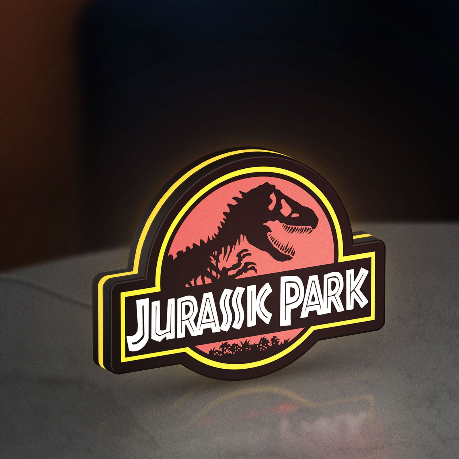 Jurassic Park LED lightbox standing on a desk from an angled side view with yellow glow