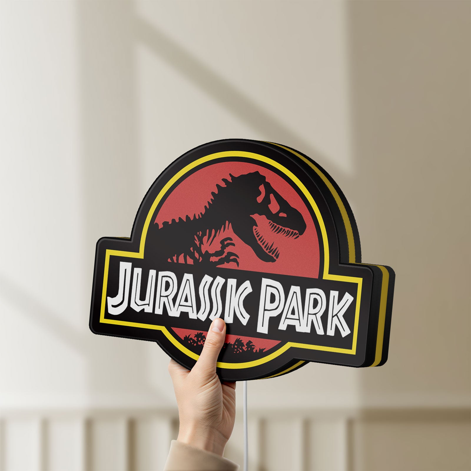 Unlit Jurassic Park LED lightbox held by hand to show size and details