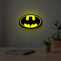 Batman LED lightbox hanging on a room wall with soft yellow light