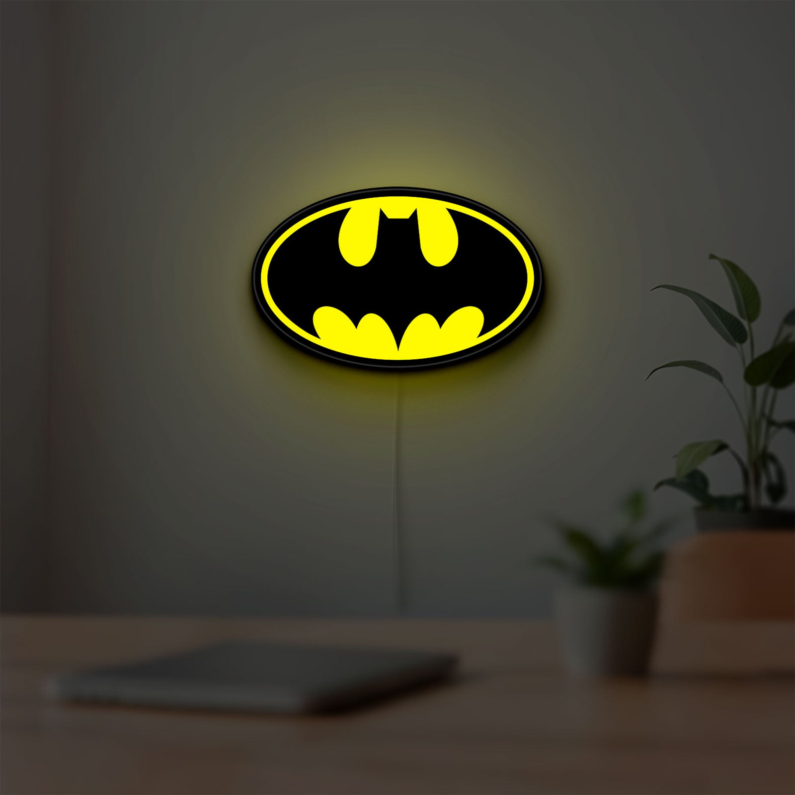 Batman LED lightbox hanging on a room wall with soft yellow light