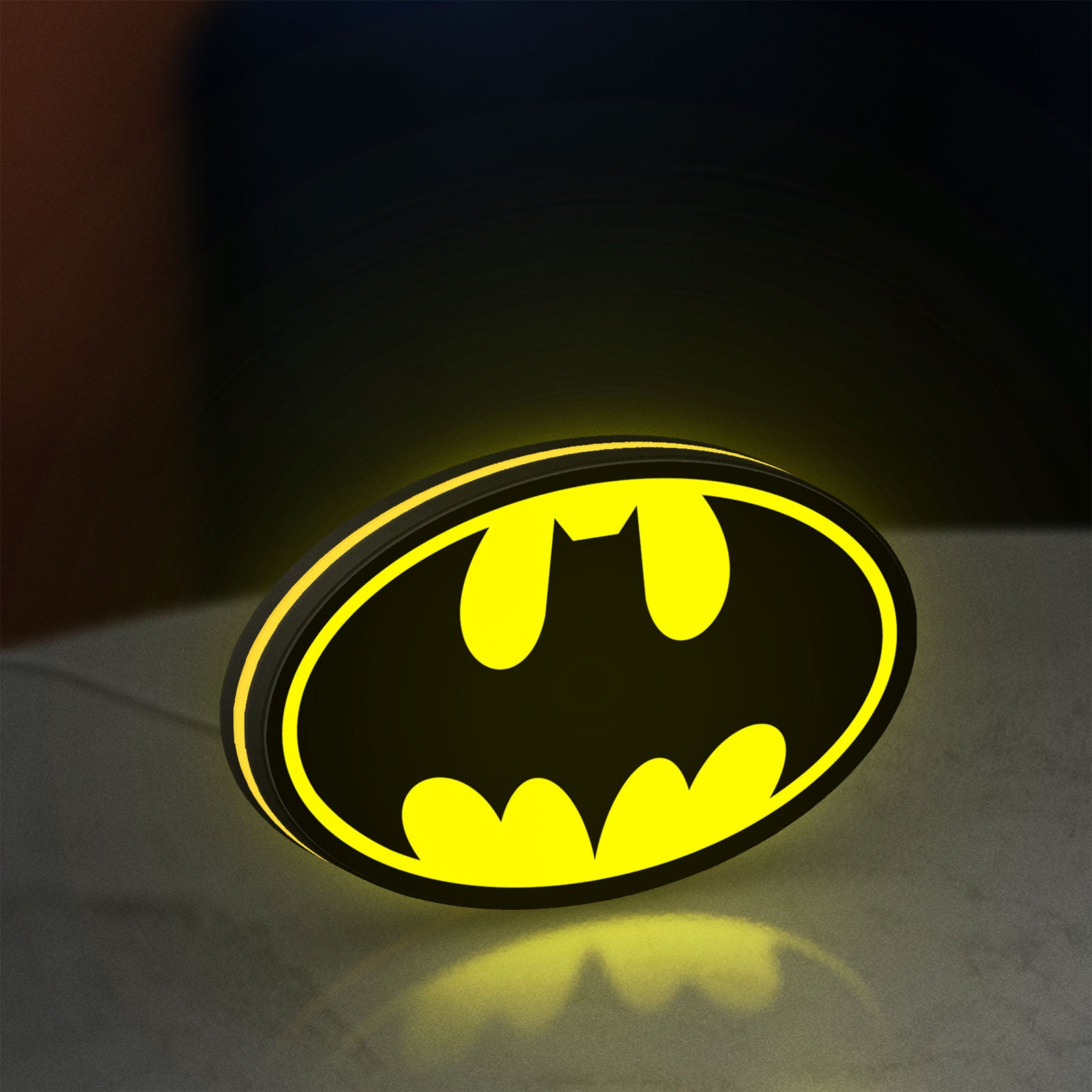 Batman LED lightbox standing on a desk from an angled side view with yellow glow