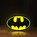 Front view of Batman LED lightbox sign glowing on a wooden desk