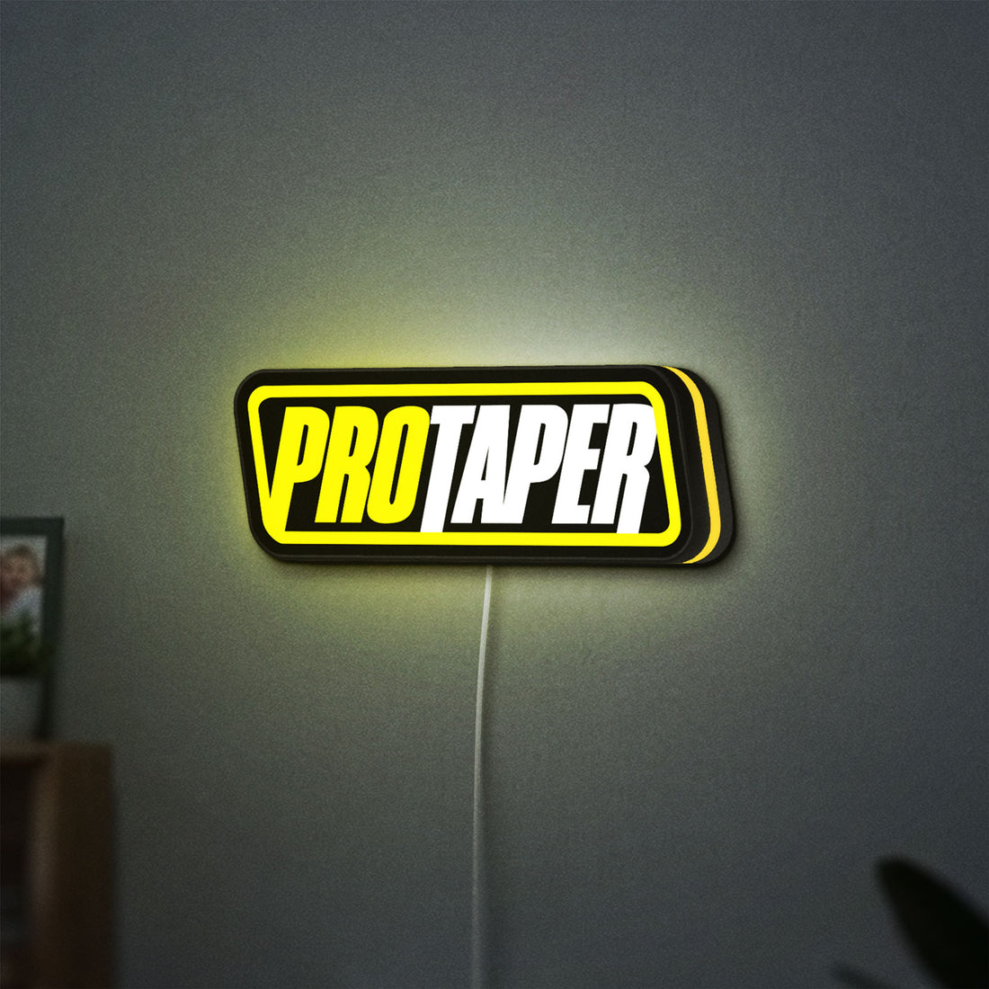 Pro Taper LED lightbox hanging on a wall with yellow glow