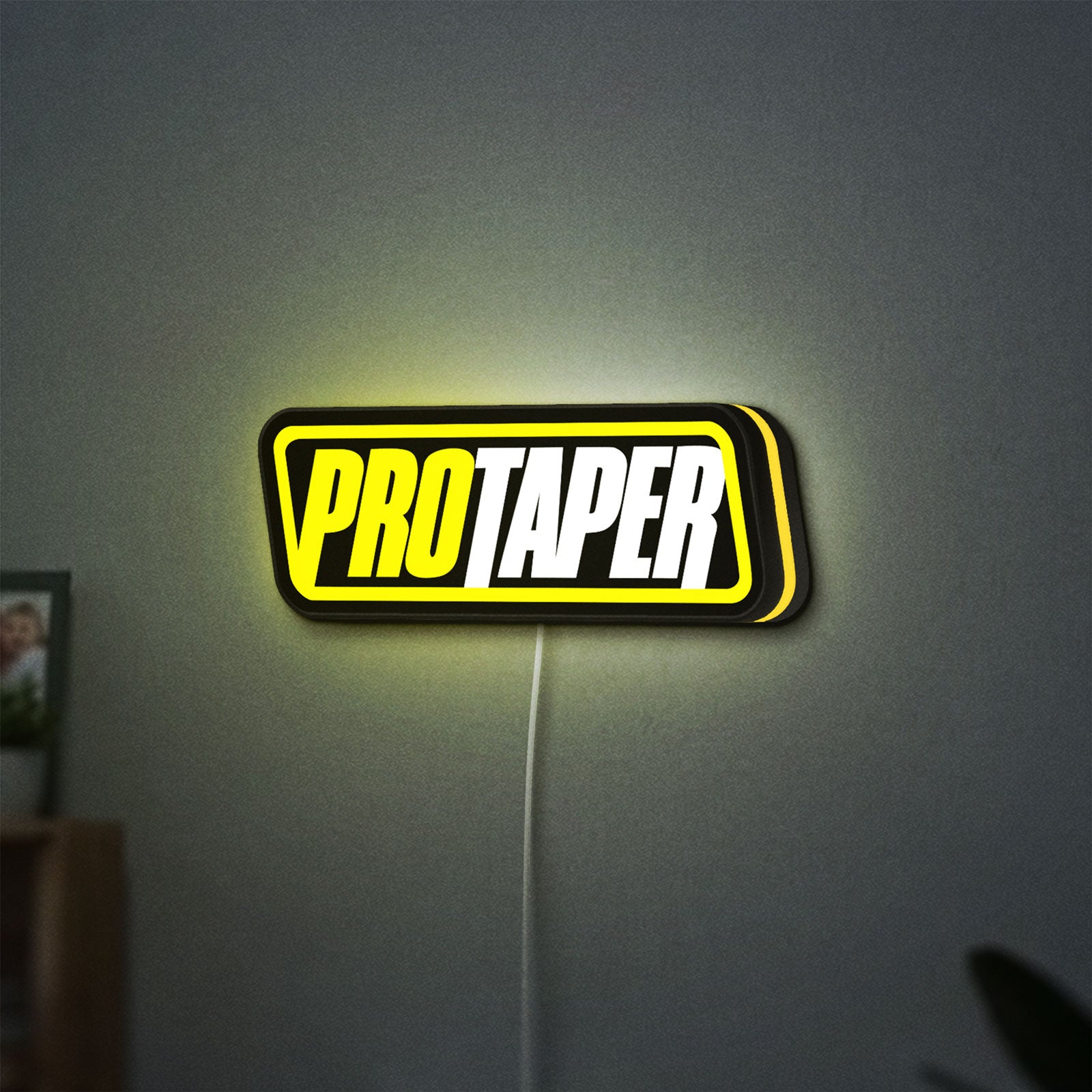 Pro Taper LED lightbox hanging on a wall with yellow glow