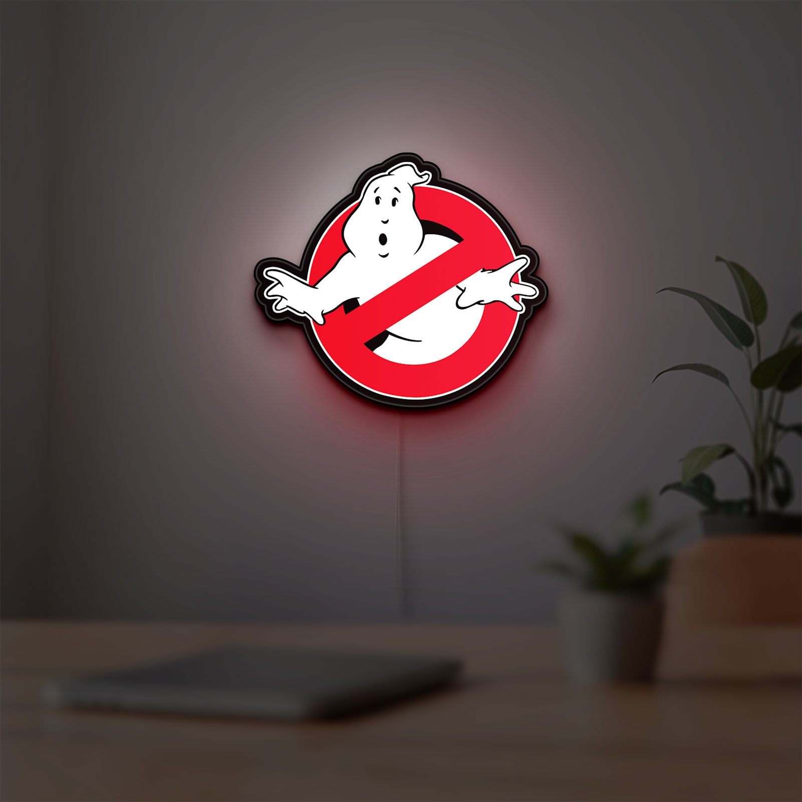 Ghostbusters LED lightbox hanging on a room wall with soft red light