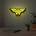 WONDER WOMAN LED lightbox hanging on a room wall with soft yellow light