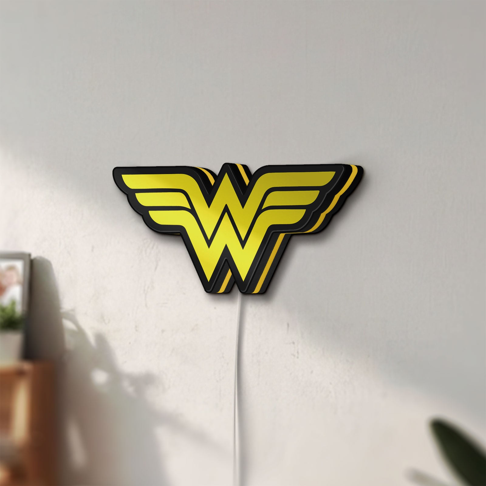 Unlit WONDER WOMAN LED lightbox mounted on a wall in daylight