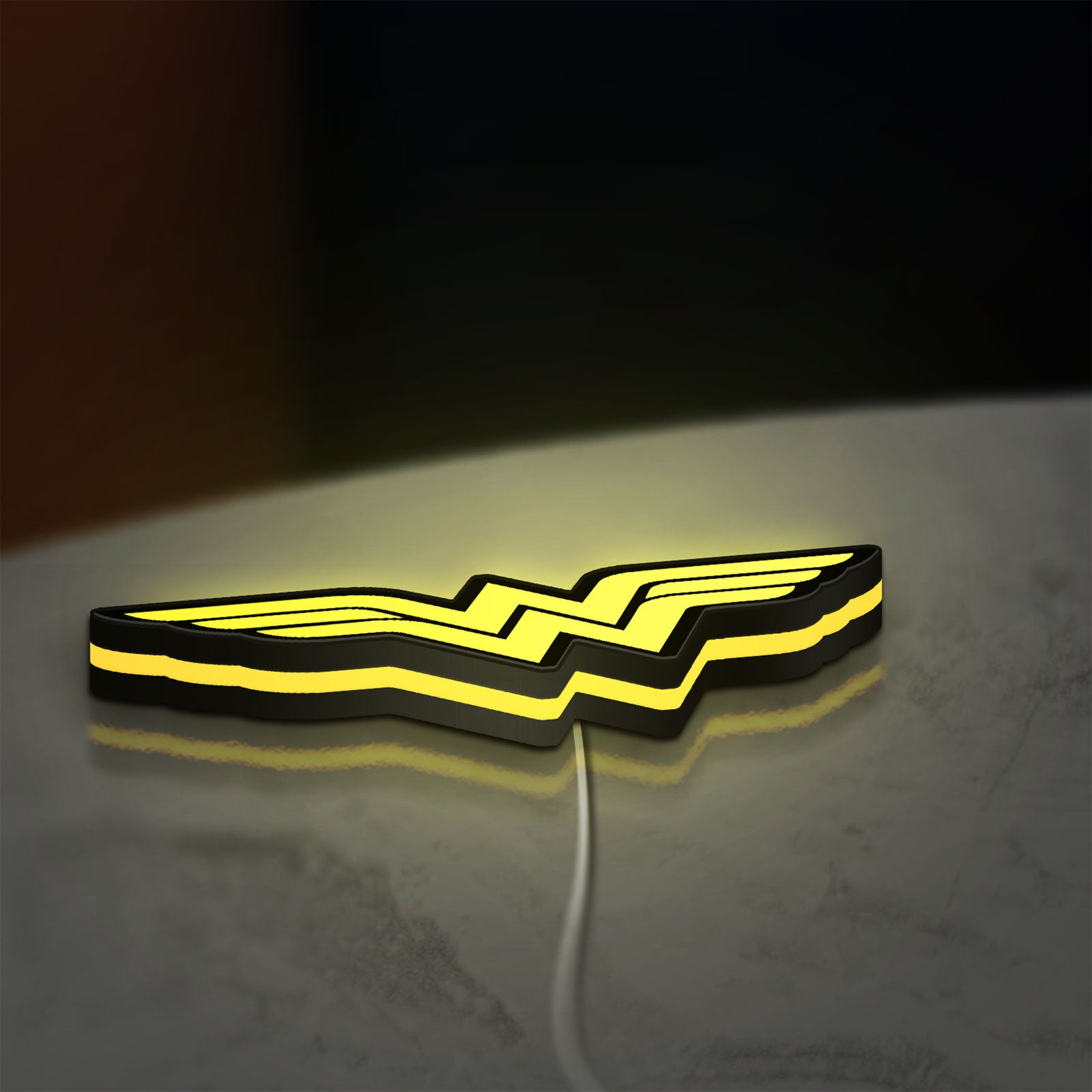 WONDER WOMAN LED lightbox lying flat on a desk with yellow glow
