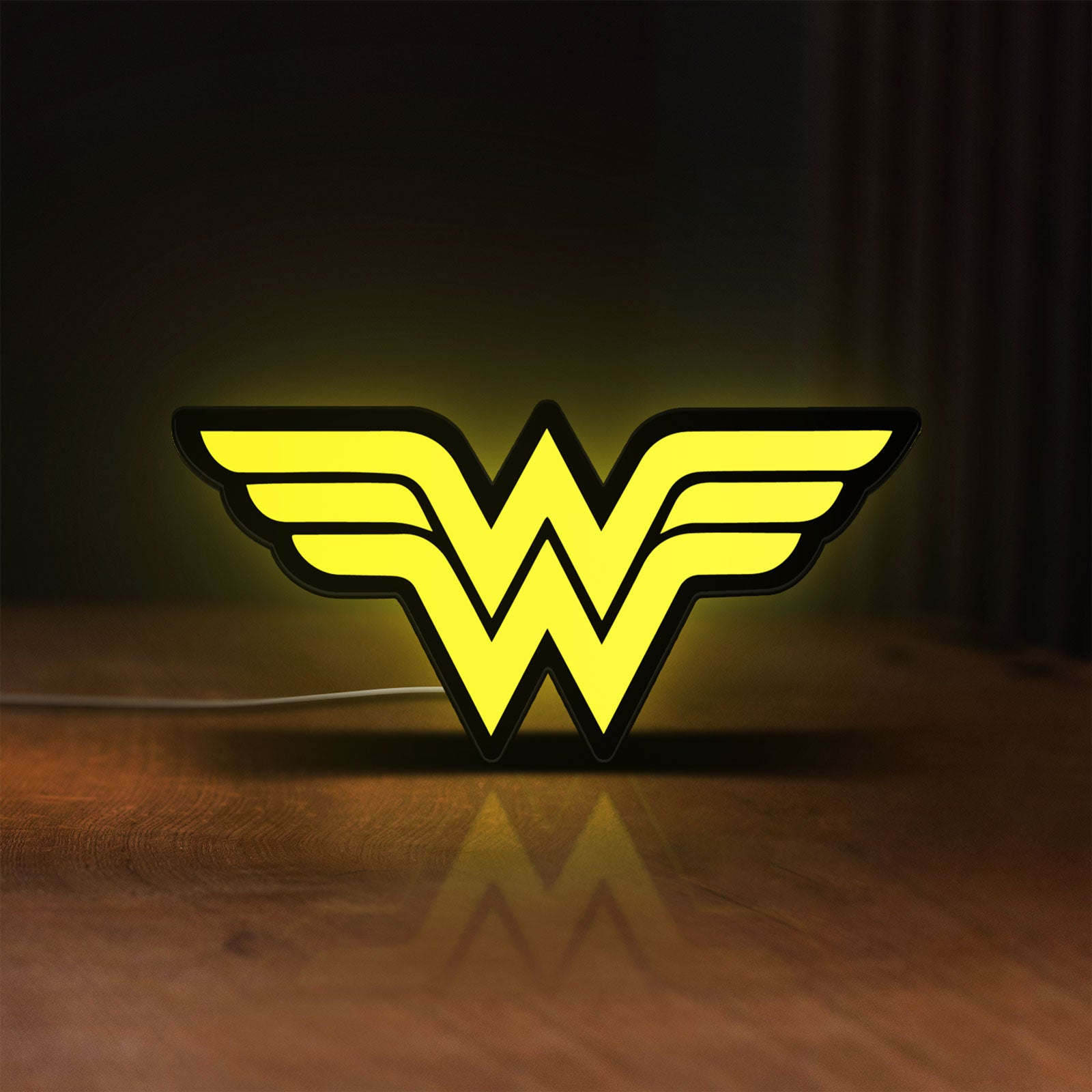 Front view of WONDER WOMAN LED lightbox sign glowing on a wooden desk