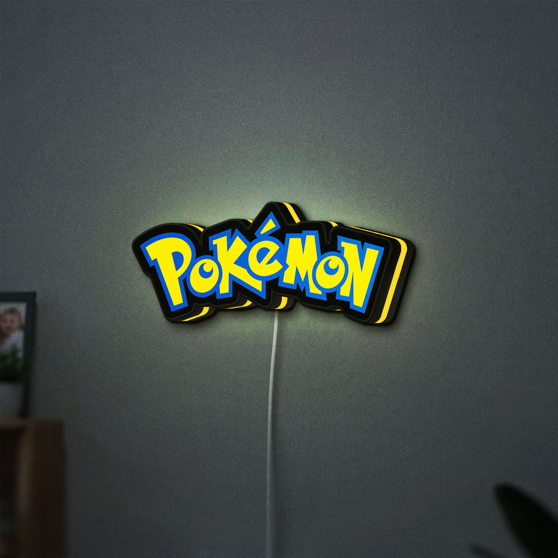 Pokemon LED lightbox hanging on a wall with yellow glow