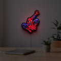 Spider-Man LED lightbox hanging on a room wall with soft red light