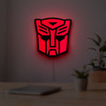 Autobot LED lightbox hanging on a room wall with soft red light