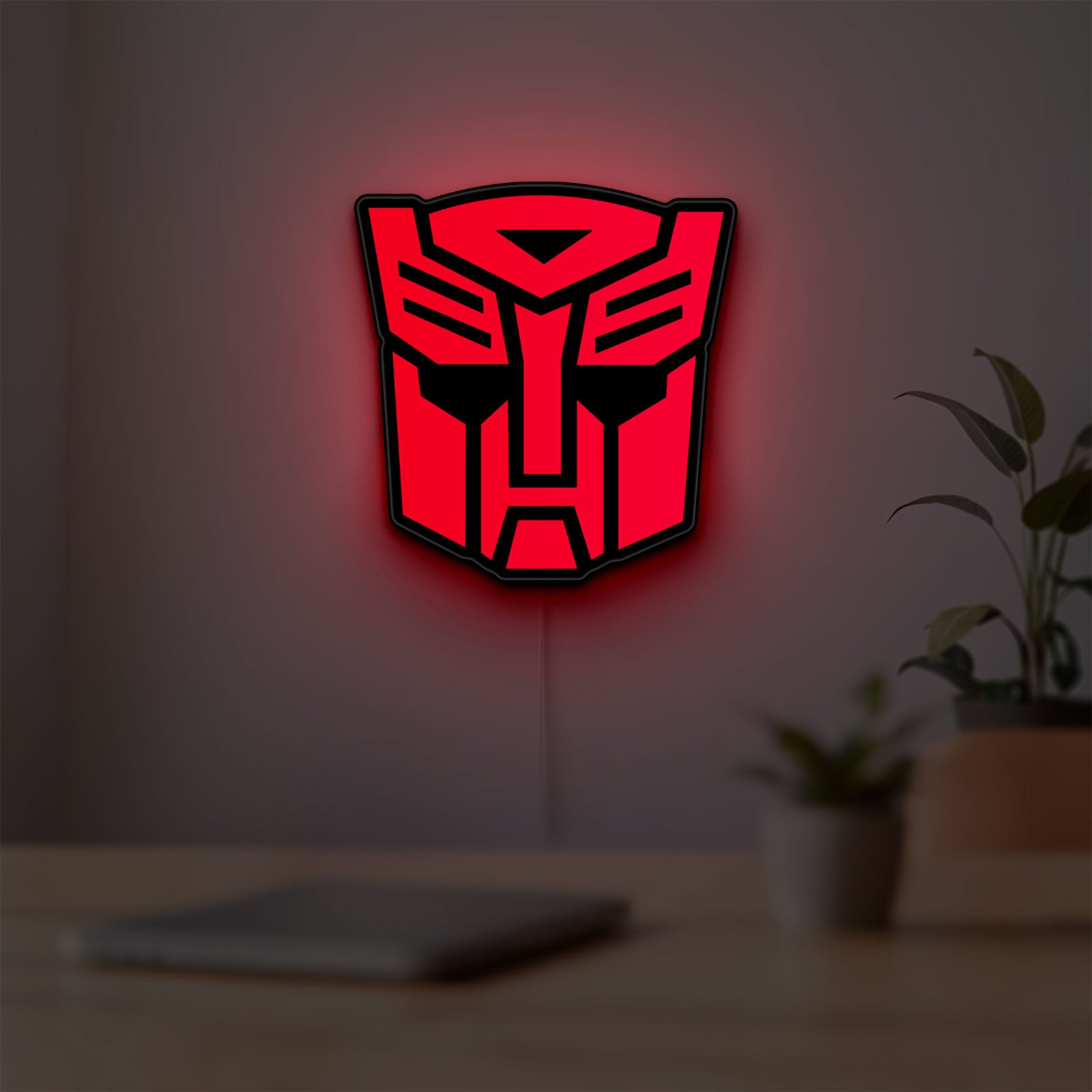 Autobot LED lightbox hanging on a room wall with soft red light