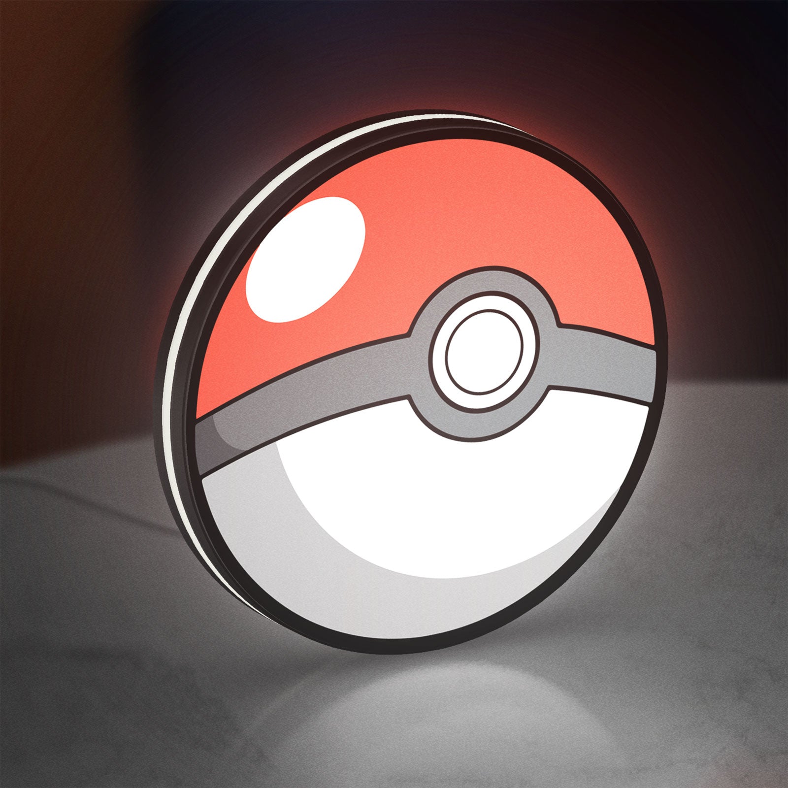 Pokeball LED lightbox standing on a desk from an angled side view with white glow
