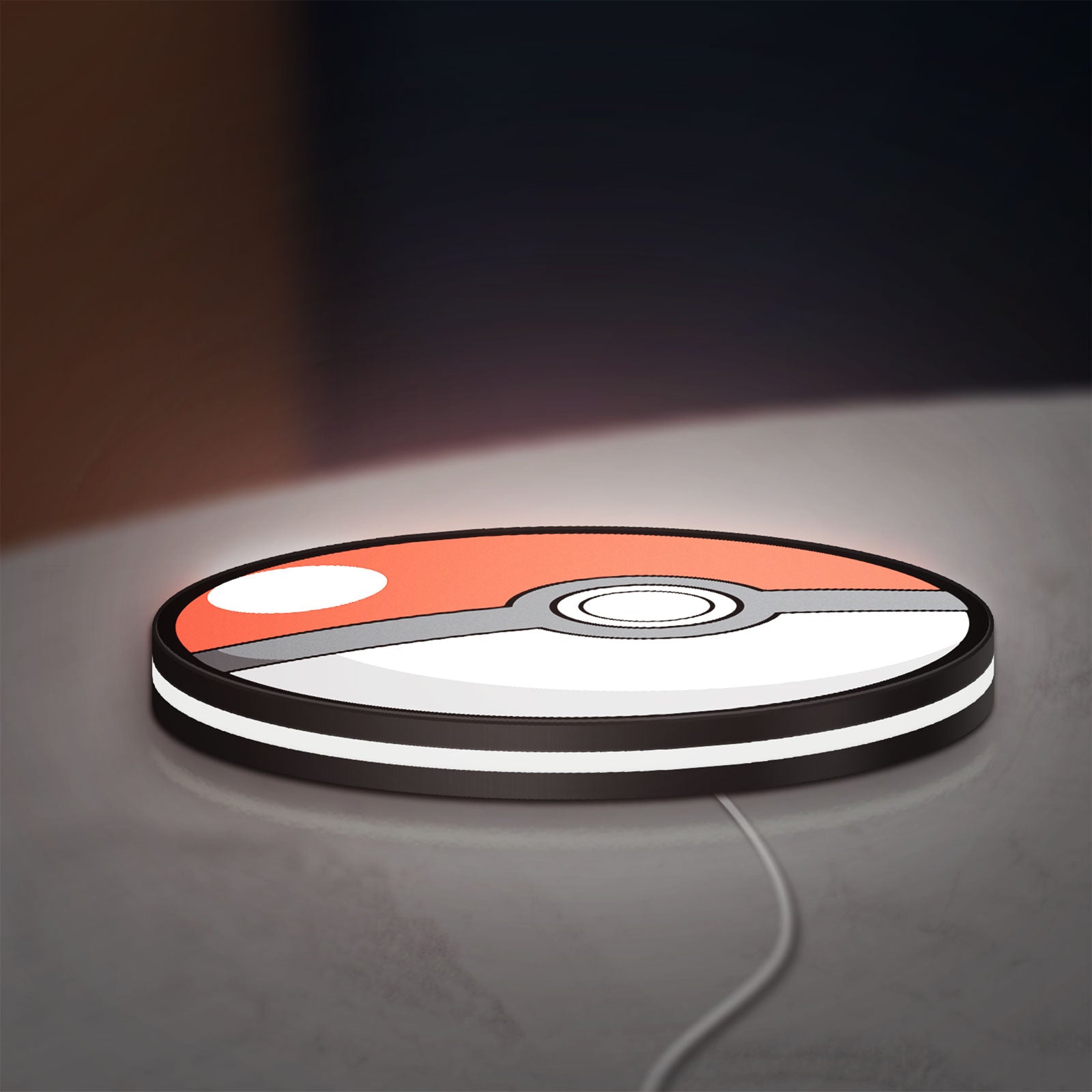 Pokeball LED lightbox lying flat on a desk with white glow