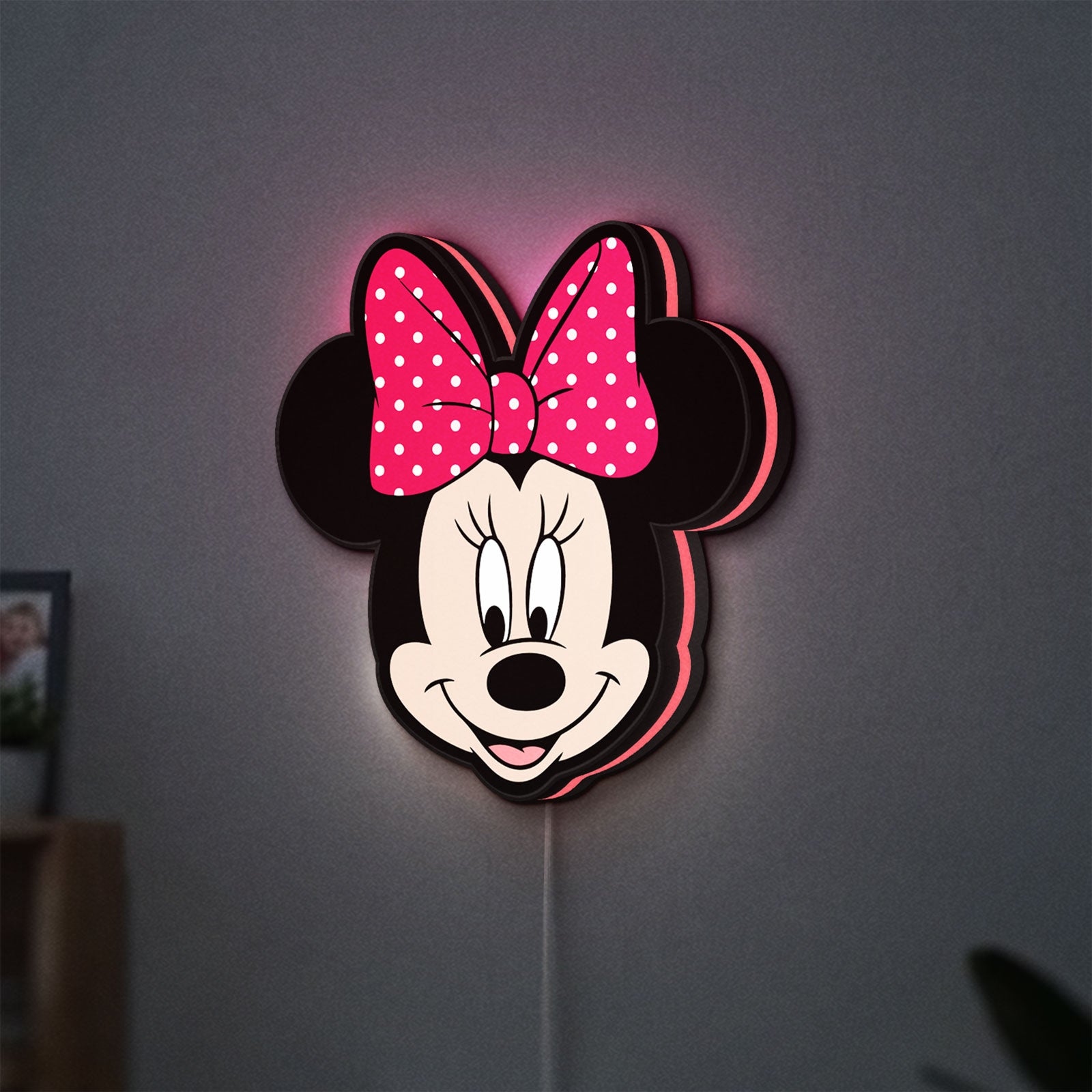 Minnie Mouse Head LED lightbox hanging on a wall with pink glow