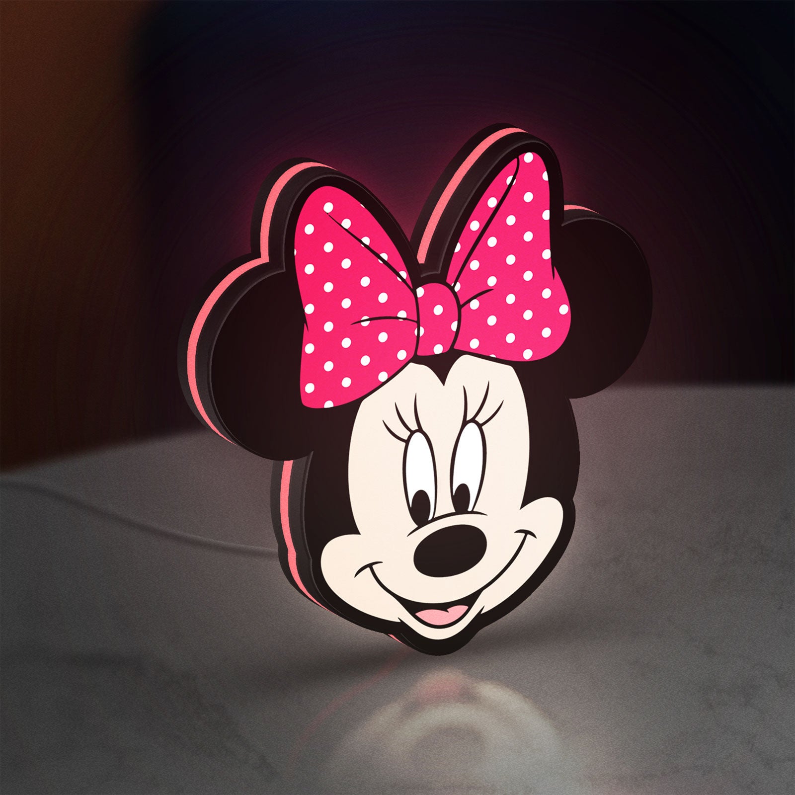 Minnie Mouse Head LED lightbox standing on a desk from an angled side view with pink glow