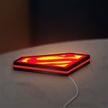 Superman S LED lightbox lying flat on a desk with red glow