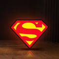 Front view of Superman S LED lightbox sign glowing on a wooden desk