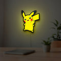 Pikachu LED lightbox hanging on a room wall with soft yellow light