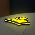 Pikachu LED lightbox lying flat on a desk with yellow glow