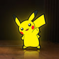 Front view of Pikachu LED lightbox sign glowing on a wooden desk