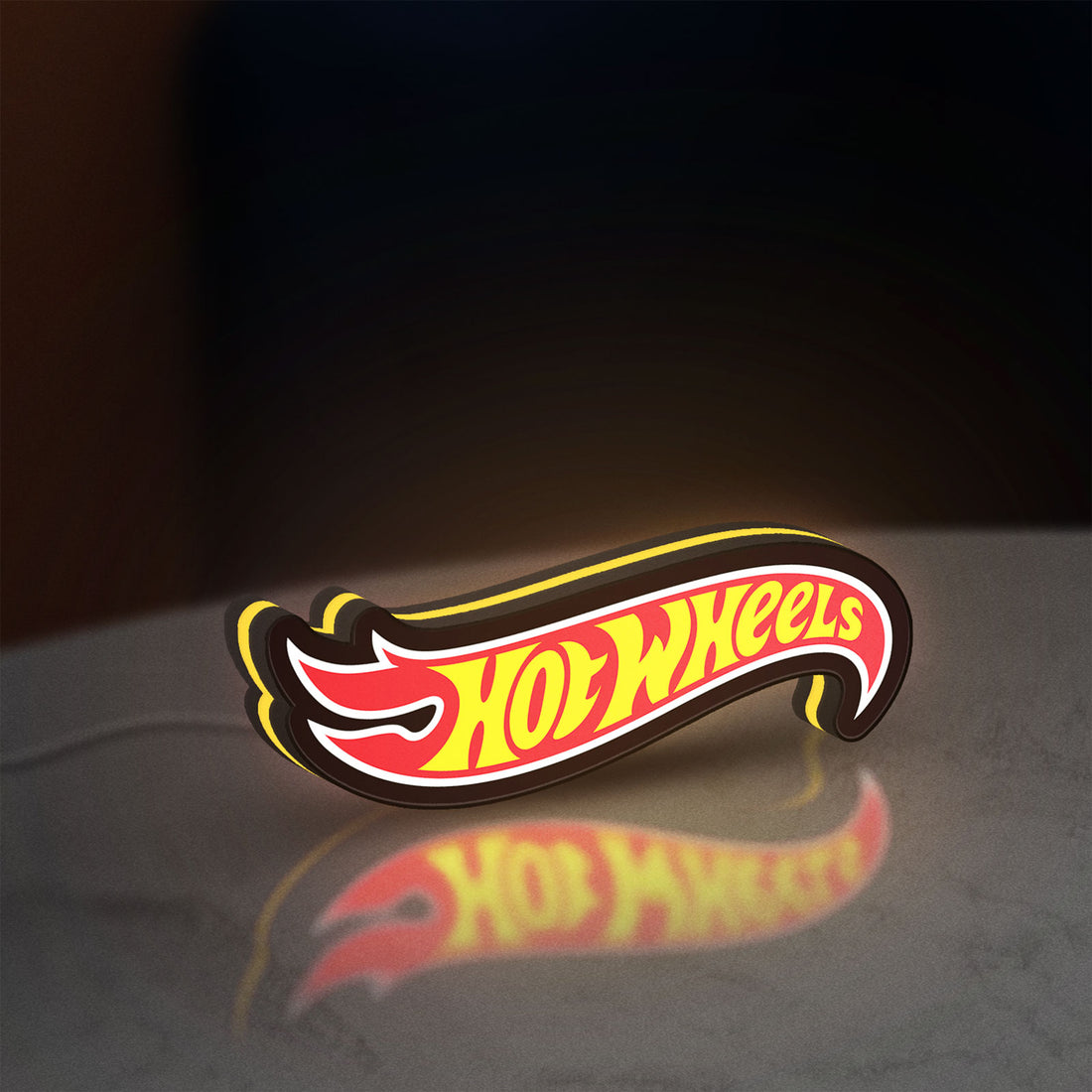 Hot Wheels Sign LED lightbox hanging on a wall with yellow glow