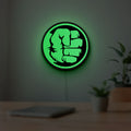Hulk Fist LED lightbox hanging on a room wall with soft green light