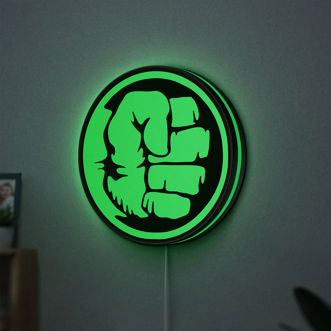 Hulk Fist LED lightbox hanging on a wall with green glow