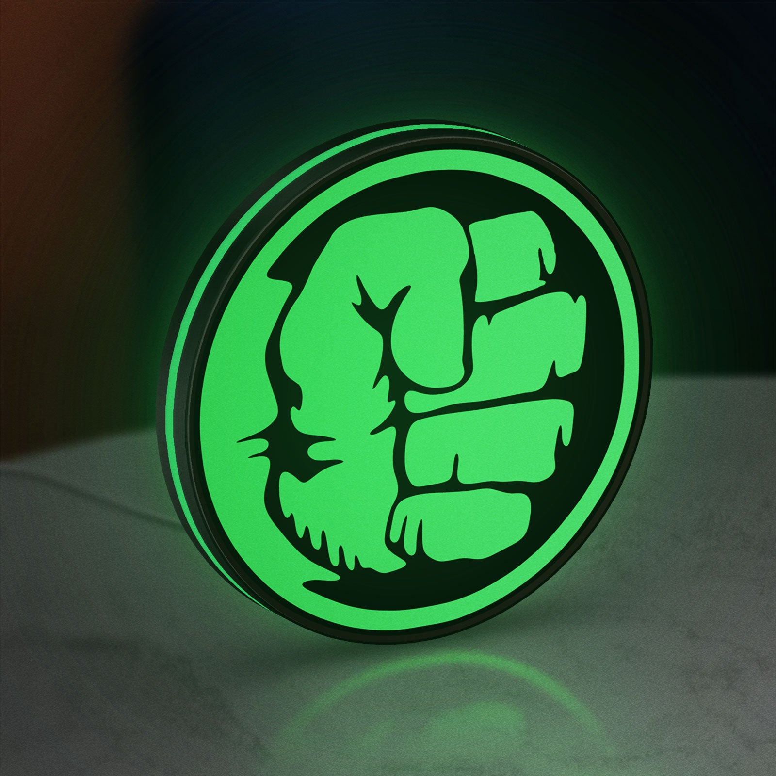 Hulk Fist LED lightbox standing on a desk from an angled side view with green glow