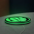 Hulk Fist LED lightbox lying flat on a desk with green glow