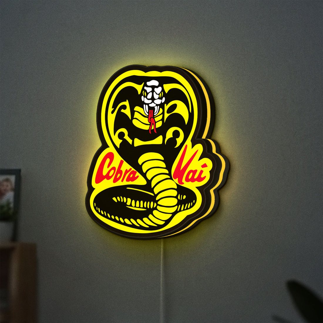 Cobra Kai LED lightbox hanging on a wall with yellow glow