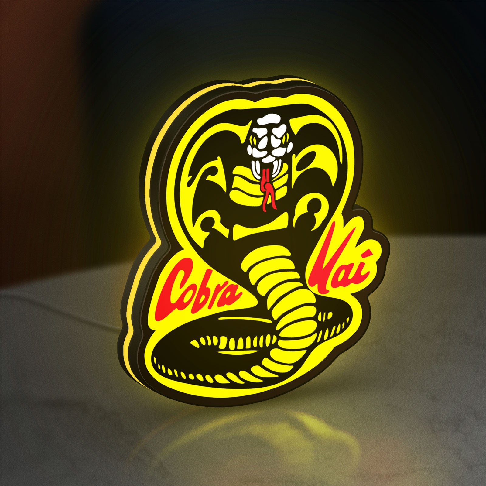 Cobra Kai LED lightbox standing on a desk from an angled side view with yellow glow