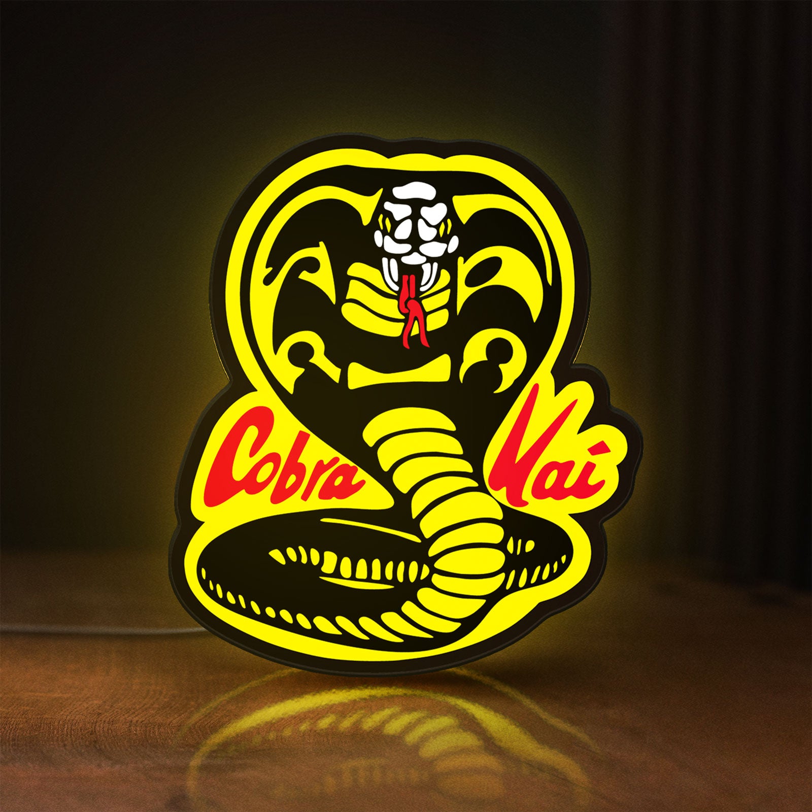 Front view of Cobra Kai LED lightbox sign glowing on a wooden desk